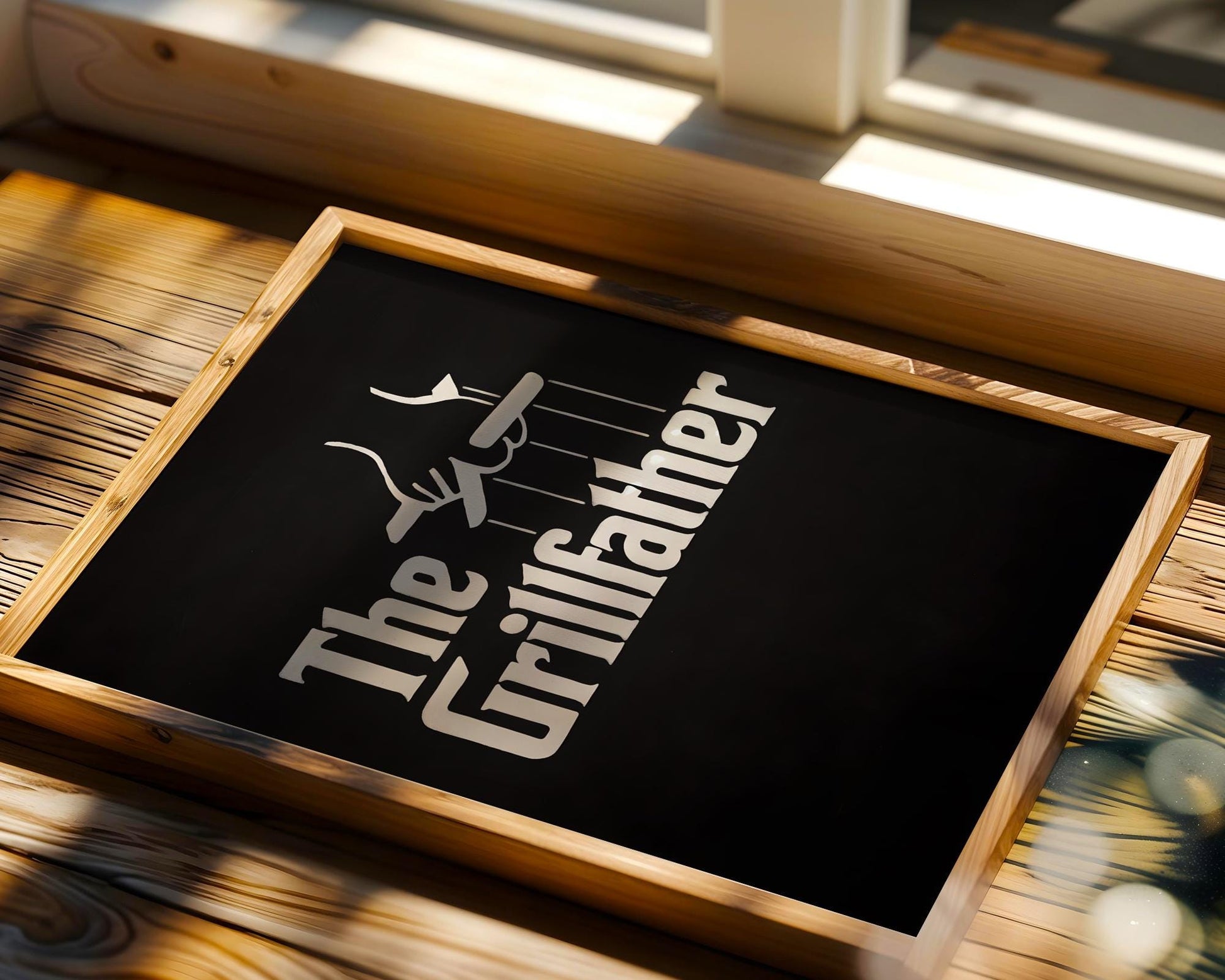 Bold black and white chalkboard-style poster with 'The Grillfather' text parodying The Godfather, complete with puppet strings holding a grilling fork. A perfect gift for dads, BBQ fans, and grill kings, this fun and graphic design adds flavor to backyard setups, man caves, or cookout spaces with a sense of humor.
